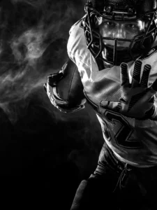Dramatic black-and-white image of an American football player in action.