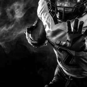 Dramatic black-and-white image of an American football player in action.