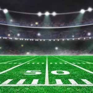Empty football field under bright stadium lights at night.